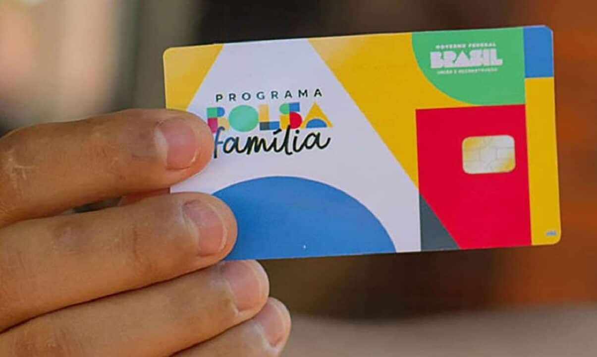 Pessoa segurando o novo cartão do Bolsa Família.